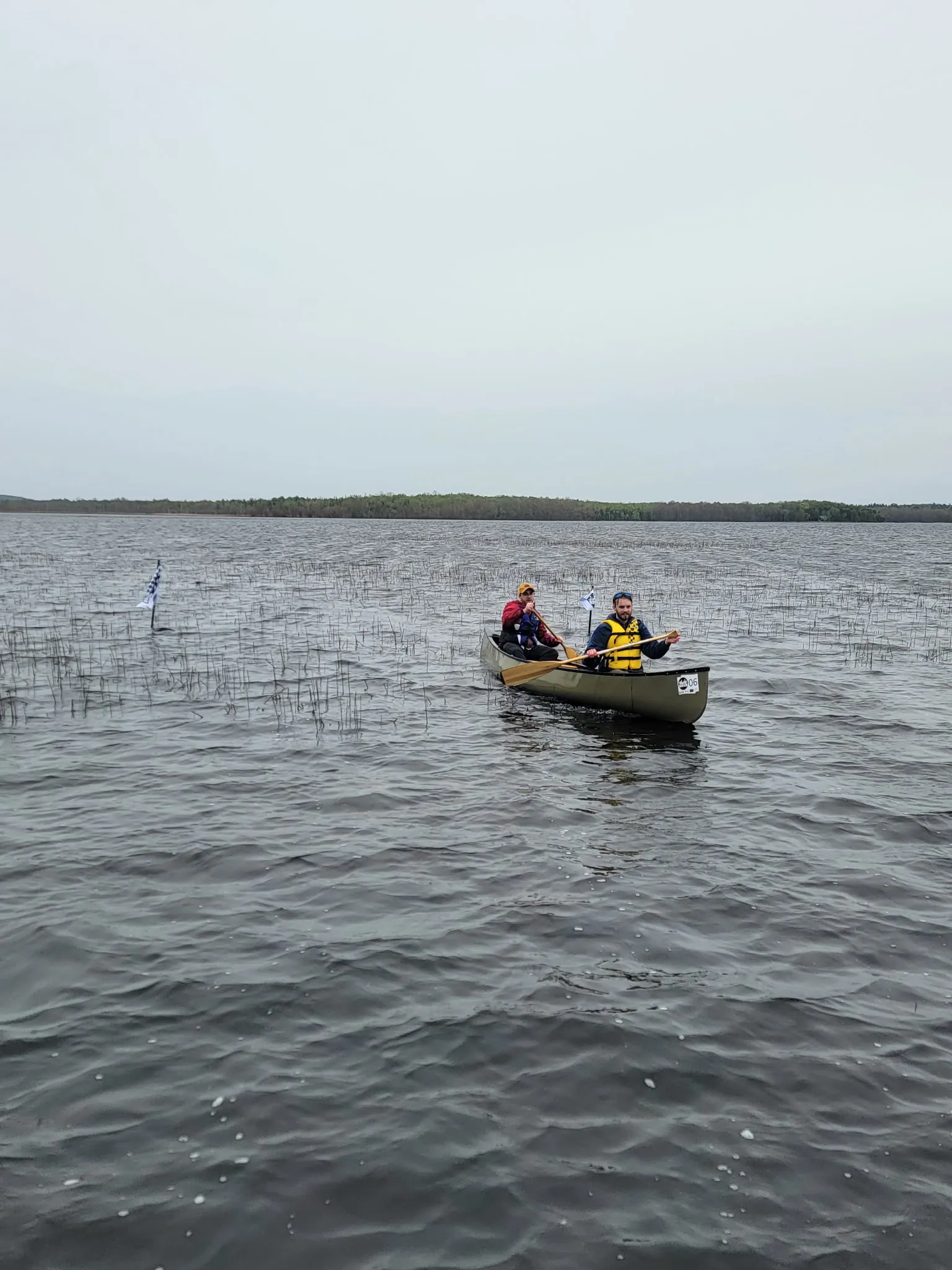A canoe crossing open water past a course marker at the 2026 Rankin River Canoe Rally